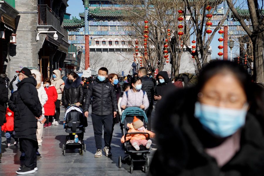 People wear face masks following the Covid-19 outbreak in Beijing, China, 1 February 2022. (Florence Lo/Reuters)