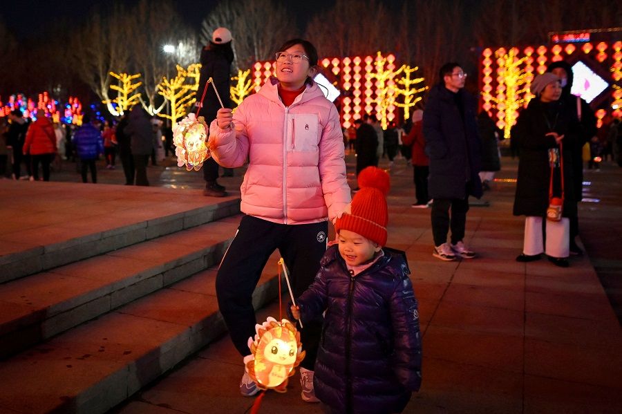 Children carrying lanterns visit a park in Beijing, China, on 24 February 2024. (Wang Zhao/AFP)