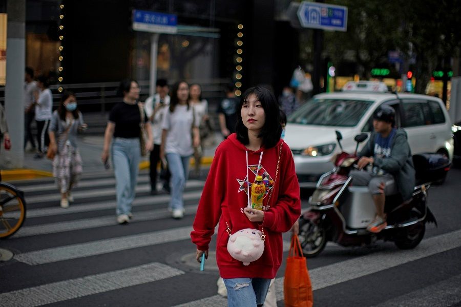 People walk along at a shopping area in Shanghai, China, 15 October 2021. (Aly Song/Reuters)