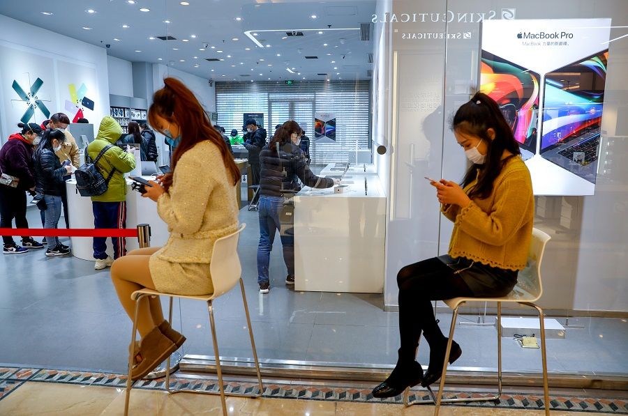 In this photo taken on 30 March, customers line up to enter a mobile phone shop in Wuhan after shopping malls resumed operations. (CNS)