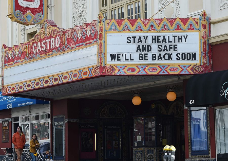A couple walks by the Castro theater with their baby in San Francisco, California on 17 March 2020. (Josh Edelson/AFP)