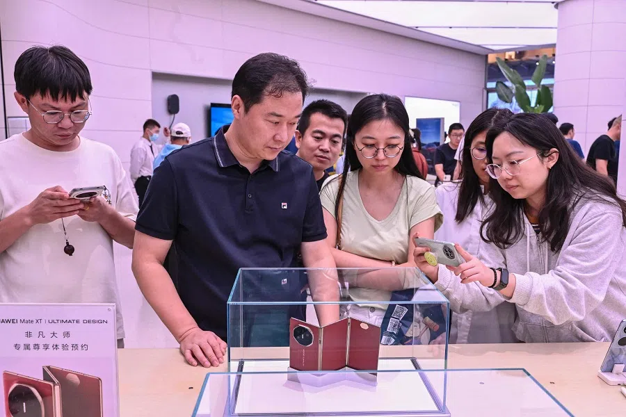 Shoppers checking out the Huawei Mate XT at a Huawei store in Beijing on 10 September 2024. Huawei on 10 September unveiled the world’s first triple-folding phone at more than three times the price of the newest iPhone, hours after its US competitor lifted the curtain on its own new handset.