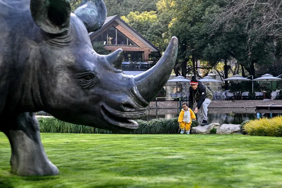 A man along with a child visits a park in the Jing’an district in Shanghai, on 18 March 2025. (Hector Retamal/AFP)