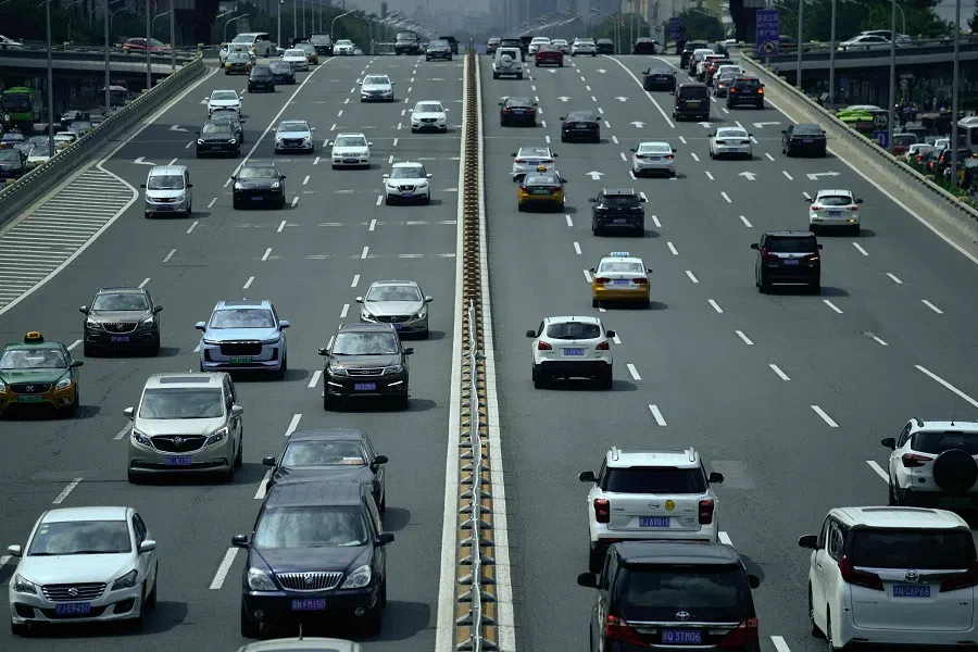 Vehicles drive down a street in Beijing, China, on 24 August 2021. (Wang Zhao/AFP)