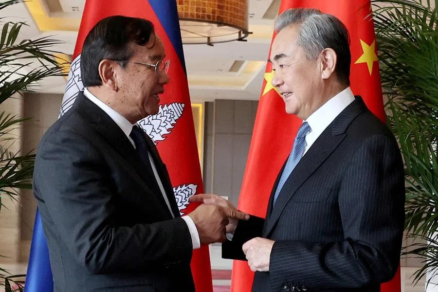 This handout photo taken and released by Agence Kampuchea Press on 28 December 2025 shows China's Foreign Minister Wang Yi (R) shaking hands with Cambodia's Deputy Prime Minister Prak Sokhonn (L), who is also the country's foreign minister, during a meeting in China's Yunnan province. (Agence Kampuchea Presse/AFP)