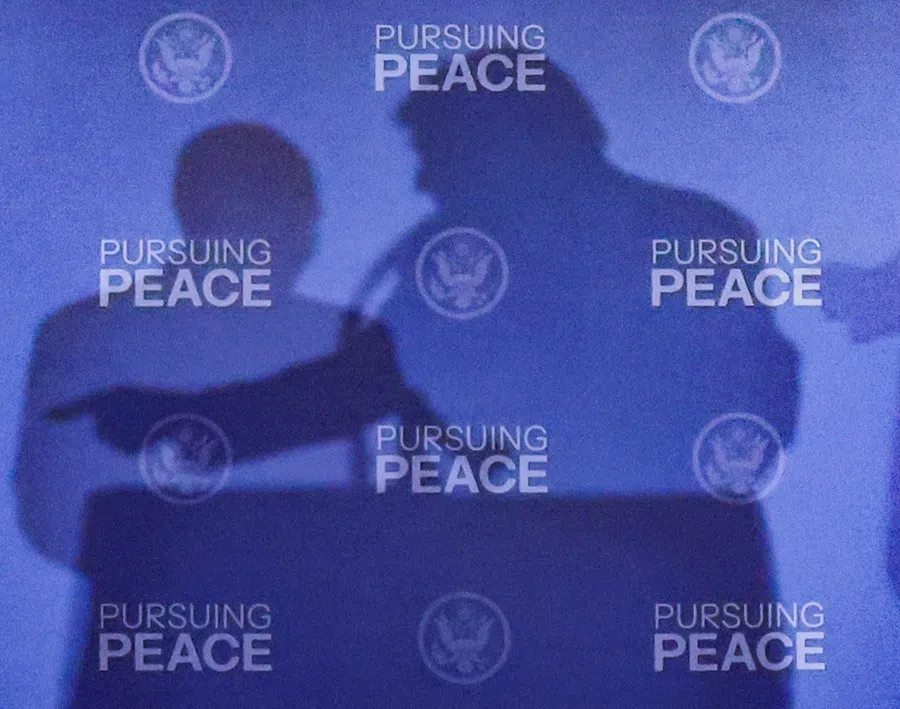 The shadows of US President Donald Trump and Russian President Vladimir Putin are cast during a press conference following their meeting to negotiate an end to the war in Ukraine, at Joint Base Elmendorf-Richardson, in Anchorage, Alaska, US, on 15 August 2025. (Kevin Lamarque/Reuters)