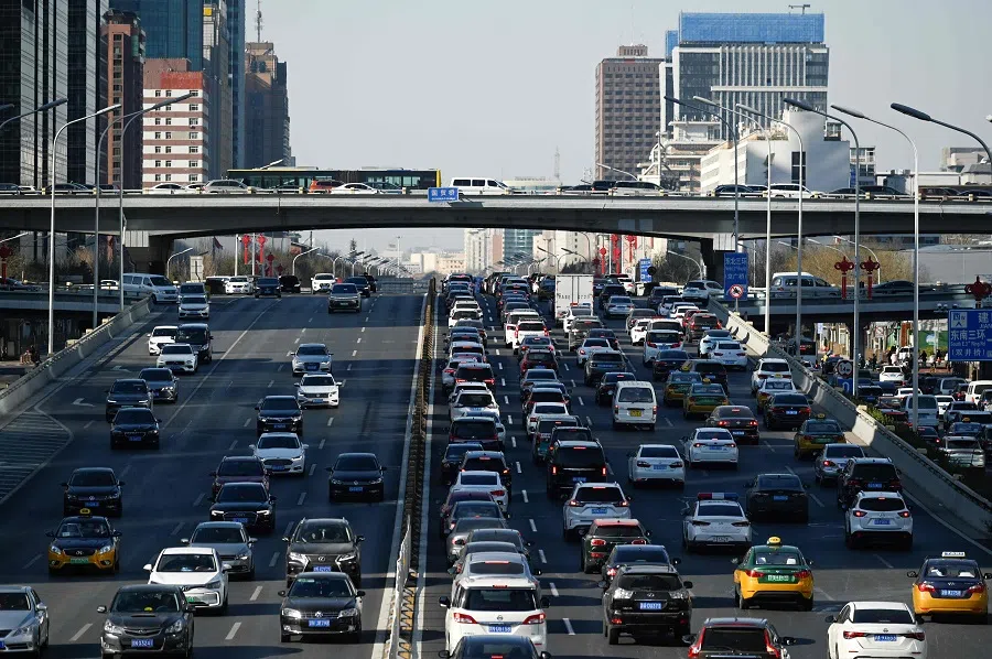 Vehicles drive along a street at the central business district in Beijing, China, on 16 January 2023. (Wang Zhao/AFP)