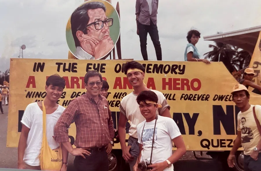The younger brother of the assassinated Benigno Aquino Jr in front of a political banner commemorating the late senator, 1986.