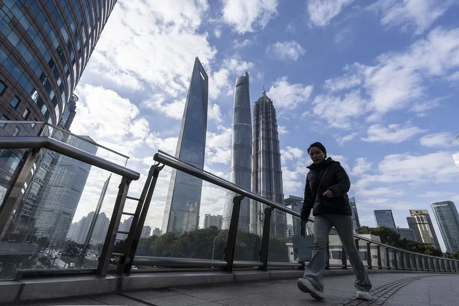 A pedestrian passes buildings in Pudong’s Lujiazui Financial District in Shanghai, China on 2 January 2025.