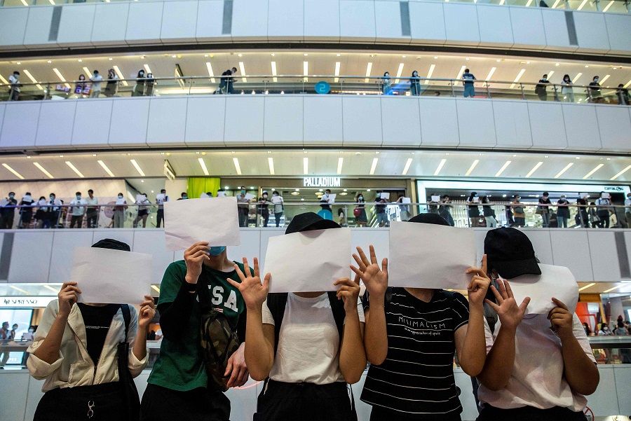 In this file picture taken on 6 July 2020, protesters hold up blank papers during a demonstration in a mall in Hong Kong, in response to a new national security law introduced in the city which makes political views, slogans and signs advocating Hong Kong's independence or liberation illegal. (Isaac Lawrence/AFP)