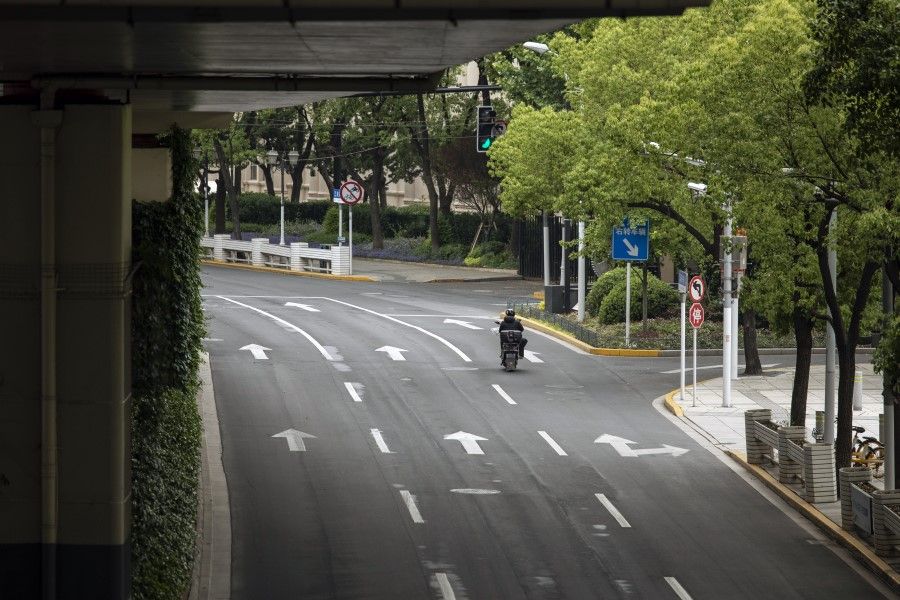 A delivery worker rides a motorcycle rides along a near-empty road during a lockdown due to Covid-19 in Shanghai, China, on 16 May 2022. (Bloomberg)