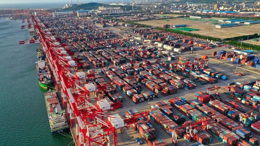 This aerial photo taken on 10 August 2023 shows cranes and shipping containers at Yingkou port, in China's northeastern Liaoning province. (Photo by AFP)