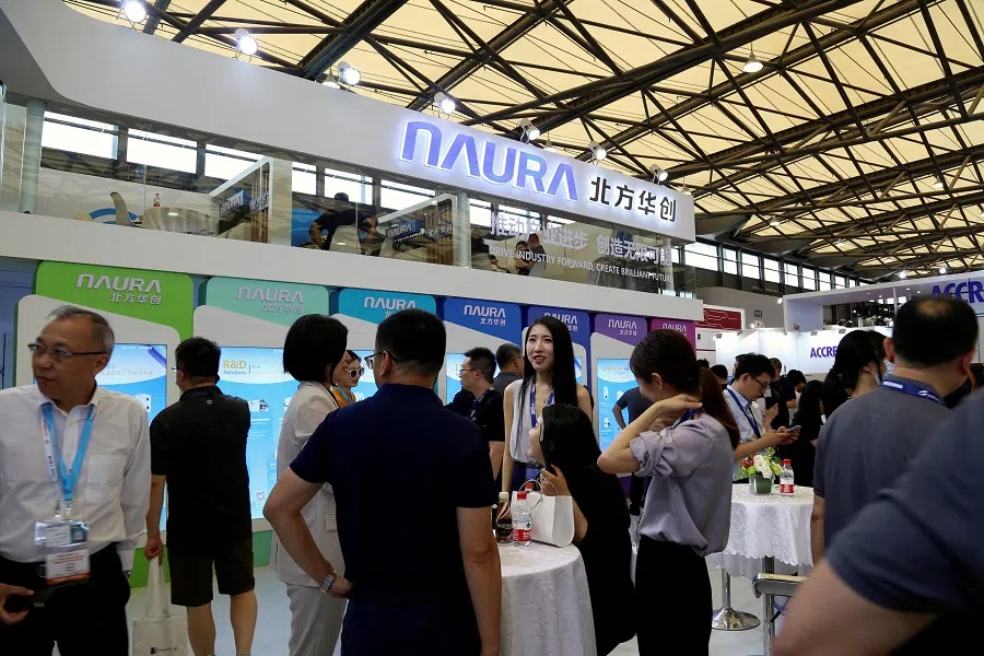 People visit the Naura Microelectronics booth during Semicon China, a trade fair for the semiconductor industry, in Shanghai, China, on 29 June 2023. (Nicoco Chan/Reuters)