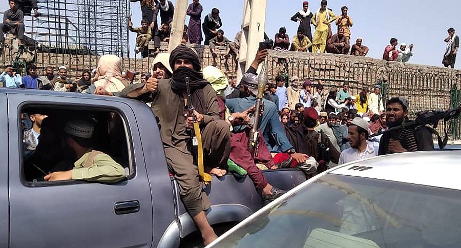 Taliban fighters sit on a vehicle along the street in Jalalabad province, Afghanistan on 15 August 2021. (AFP)
