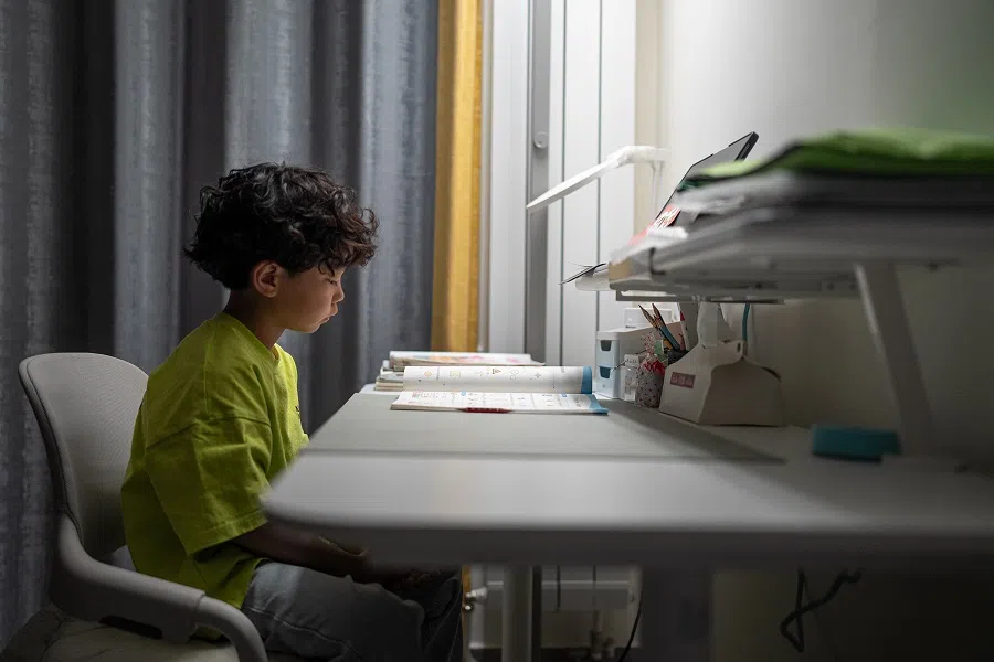 Zhuangzhuang is doing his homework. In addition to school courses, he also has dance classes, math classes, English classes and Korean classes.