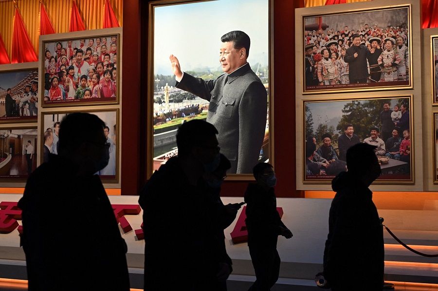 People walk past photos of Chinese President Xi Jinping at the Museum of the Communist Party of China in Beijing, China, on 3 March 2023. (Greg Baker/AFP)