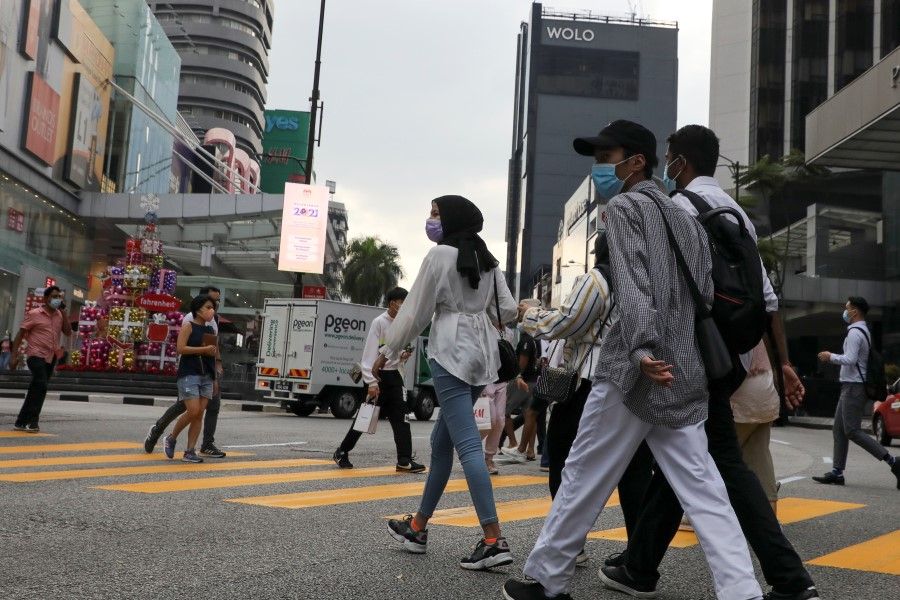 People wearing protective masks cross a street, amid the coronavirus disease (Covid-19) outbreak, in Kuala Lumpur, Malaysia, 30 November 2020. (Lim Huey Teng/REUTERS)