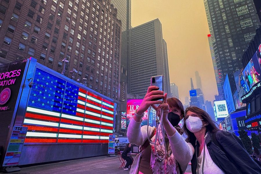 People take photos in Times Square in New York City, US, 7 June 2023. (Maye-E Wong/Reuters)