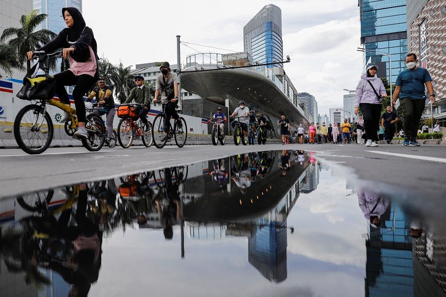 People walk and ride their bicycles in Jakarta, Indonesia, 20 November 2022. (Willy Kurniawan/Reuters)