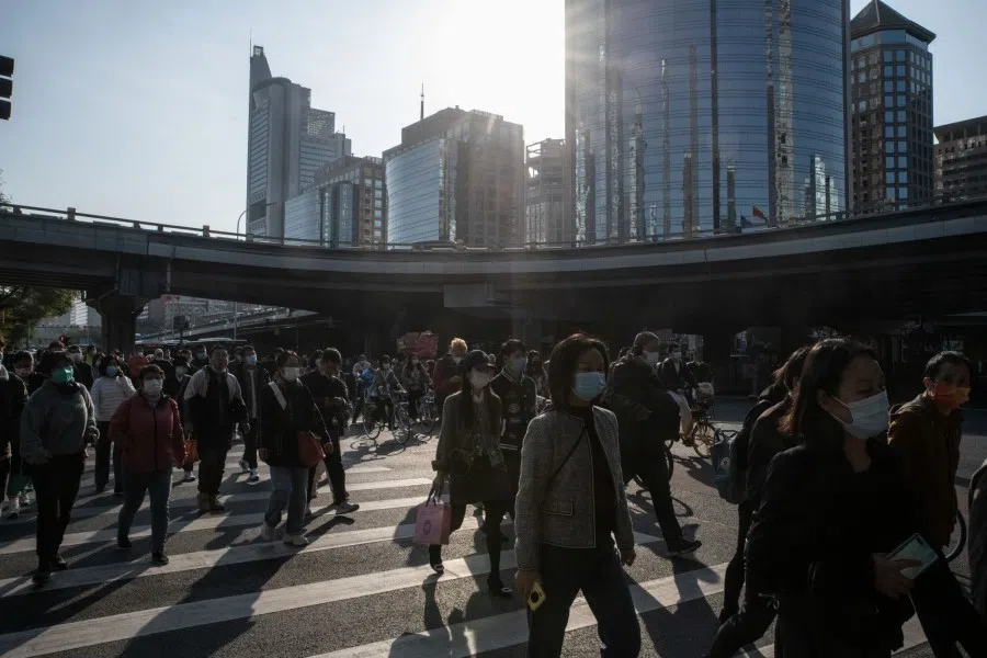 Pedestrians cross a road in Beijing, China, on 24 October 2022. (Bloomberg)