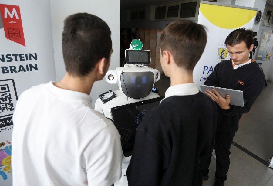 Students work on "Alnstein", a robot powered by ChatGPT, in Pascal School in Nicosia, Cyprus, 30 March 2023. (Yiannis Kourtoglou/Reuters)