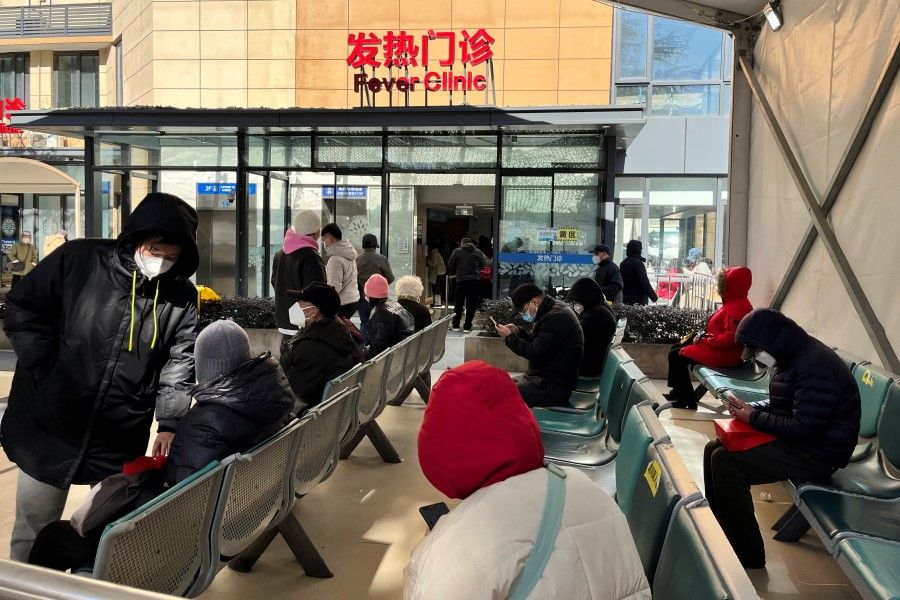 People wait outside a fever clinic at a hospital in Shanghai, China, 24 December 2022. (Reuters)
