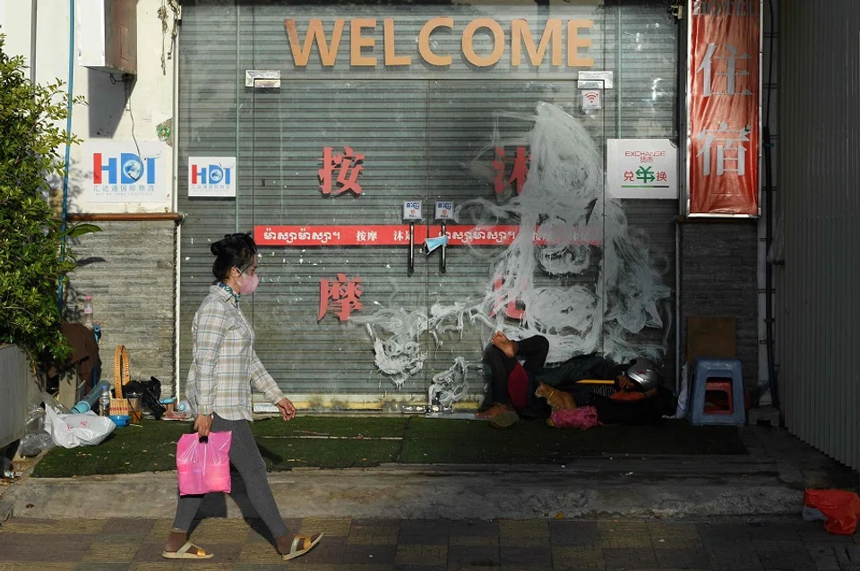 A woman walks past a closed shop in Phnom Penh, Cambodia, on 25 June 2021. (Tang Chhin Sothy/AFP)