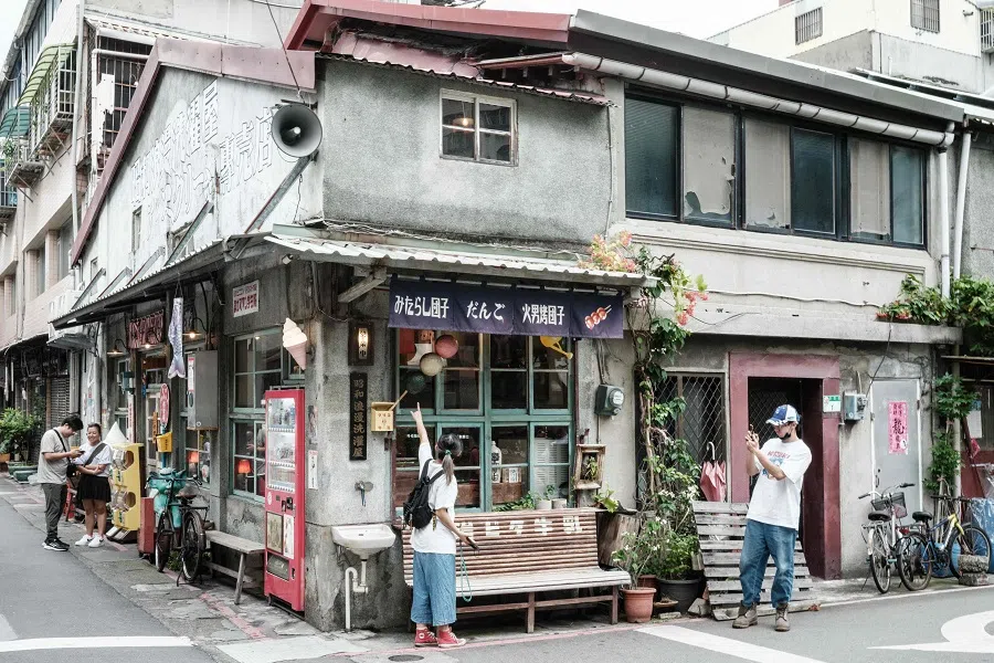 Tourists take pictures in front of a shop with Japanese antiques in Taipei on 26 May 2024. 