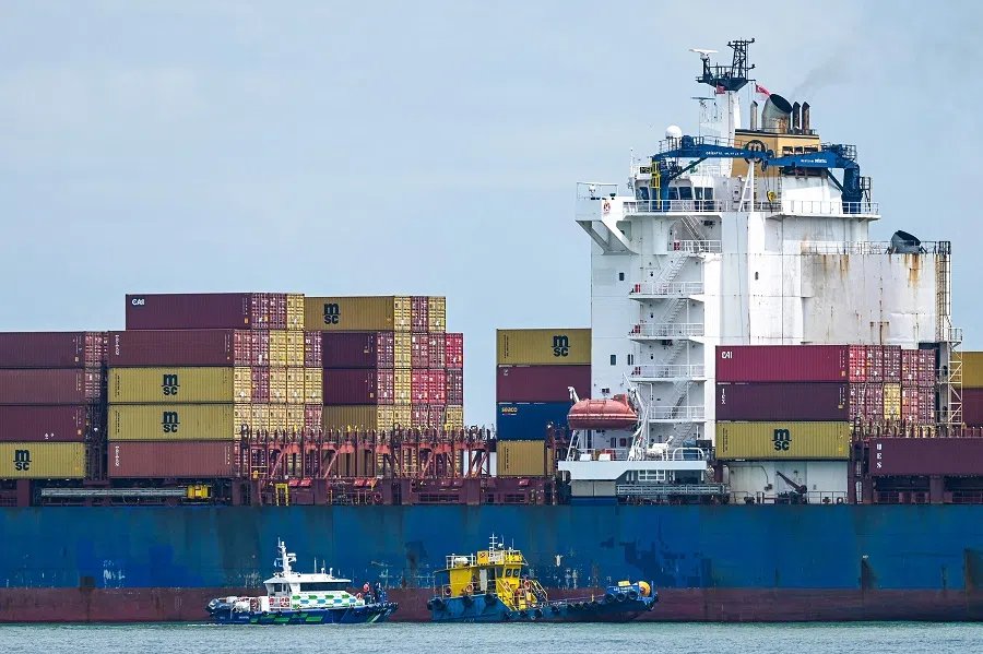 A boat from the Maritime and Port Authority of Singapore checks on a container vessel anchored off the coast of Singapore on 19 May 2025. (Roslan Rahman/AFP)