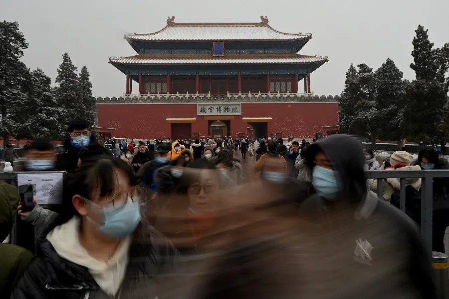 Anyone can be a victim of human trafficking. People walk at the exit gate of the Forbidden City on a snowy day in Beijing, China, on 22 January 2022. (Noel Celis/AFP)