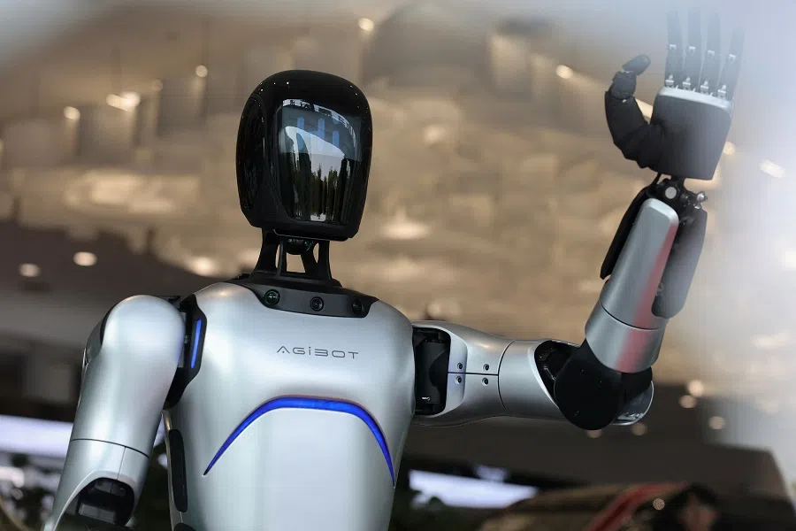 A humanoid robot waves its hand at a car dealership in Shanghai, China, 8 April 2025.
