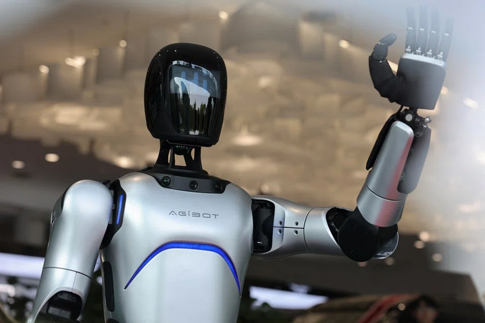 A humanoid robot waves its hand at a car dealership in Shanghai, China, 8 April 2025. (Go Nakamura/Reuters)