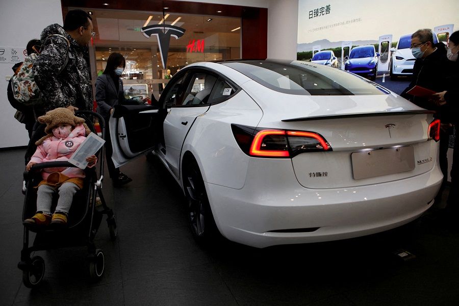 Visitors check a Tesla Model 3 car at a showroom of the US electric vehicle (EV) maker in Beijing, China, on 4 February 2023. (Florence Lo/Reuters)