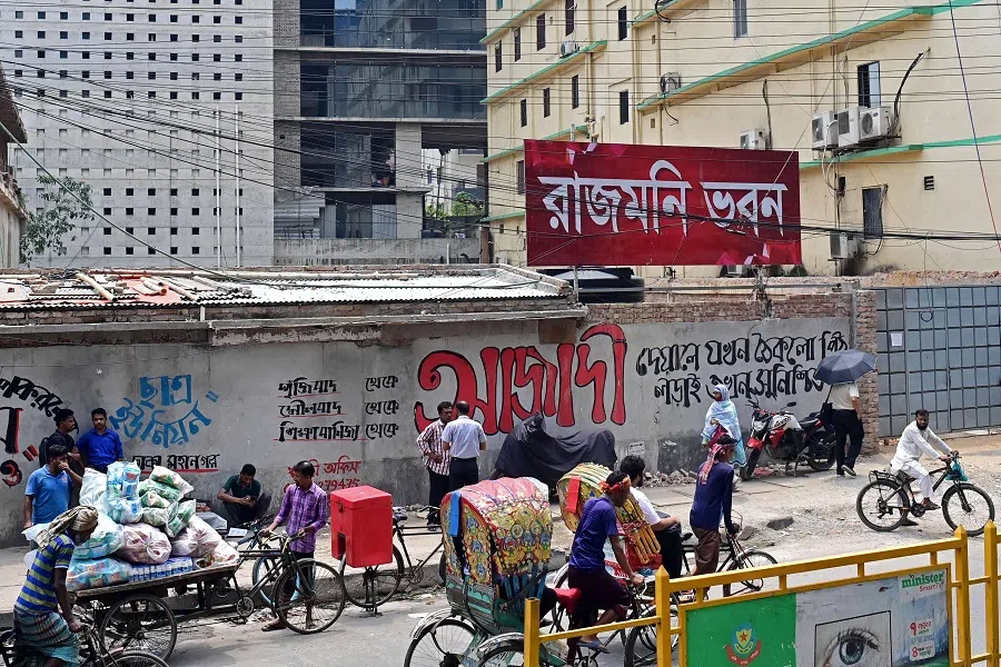 In this photograph taken on 9 May 2023, people walk past a former cinema hall in Dhaka, Bangladesh. (Munir Uz Zaman/AFP)
