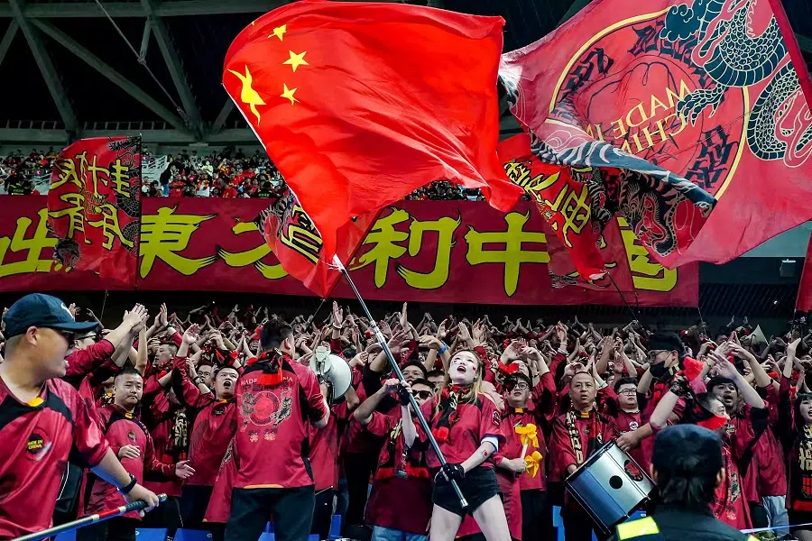 A fan waves China’s national flag to celebrate their team’s win against Indonesia at the 2026 FIFA World Cup Asian qualification football match in Qingdao, in eastern China’s Shandong province on 15 October 2024. (Stringer/AFP)