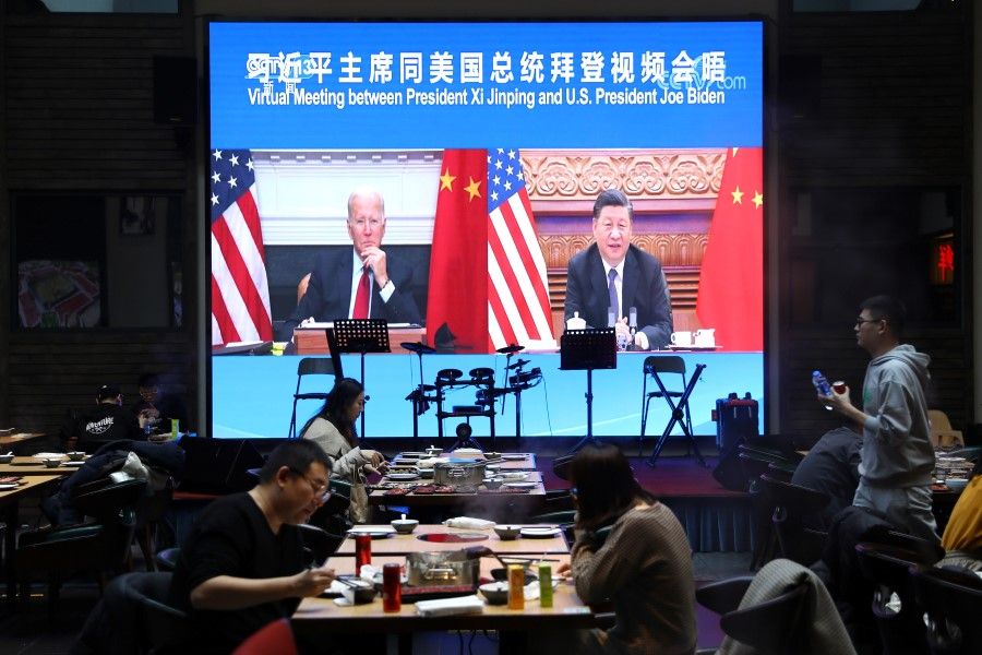 A screen shows Chinese President Xi Jinping attending a virtual meeting with US President Joe Biden via video link, at a restaurant in Beijing, China, 16 November 2021. (Tingshu Wang/Reuters)