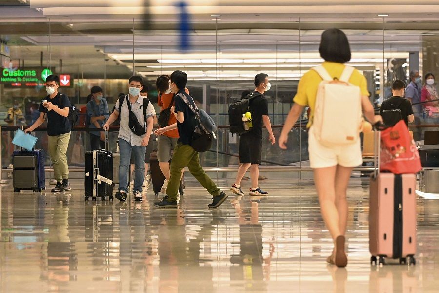 Travellers walk through a terminal at Changi Airport in Singapore on 17 July 2022. (Roslan Rahman/AFP)