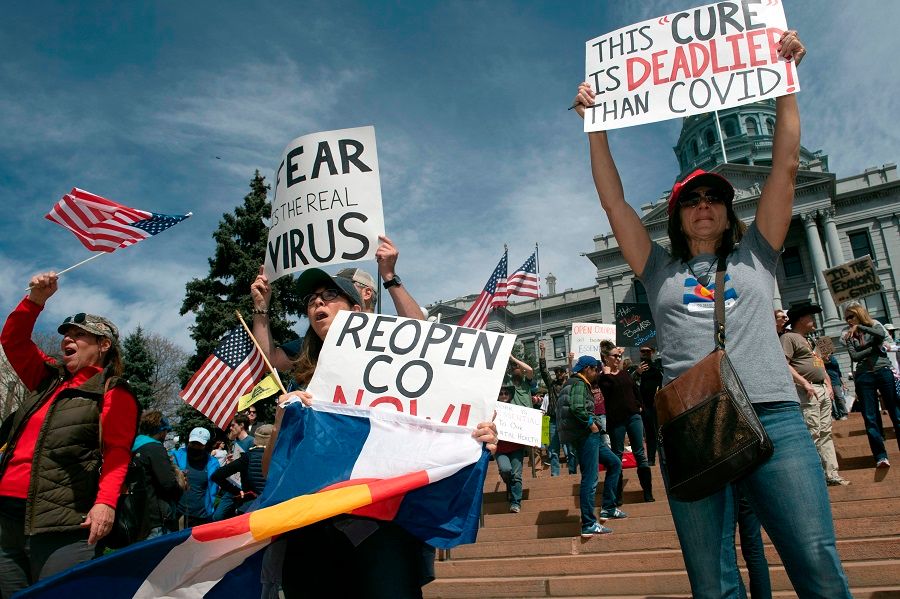Demonstrators gather in front of the Colorado State Capitol building to protest coronavirus stay-at-home orders during a "Reopen Colorado" rally in Denver, Colorado, on 19 April 2020. (Jason Connolly/AFP)
