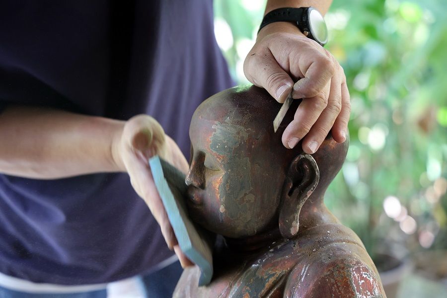 Andy Yeo restoring an idol in his studio.