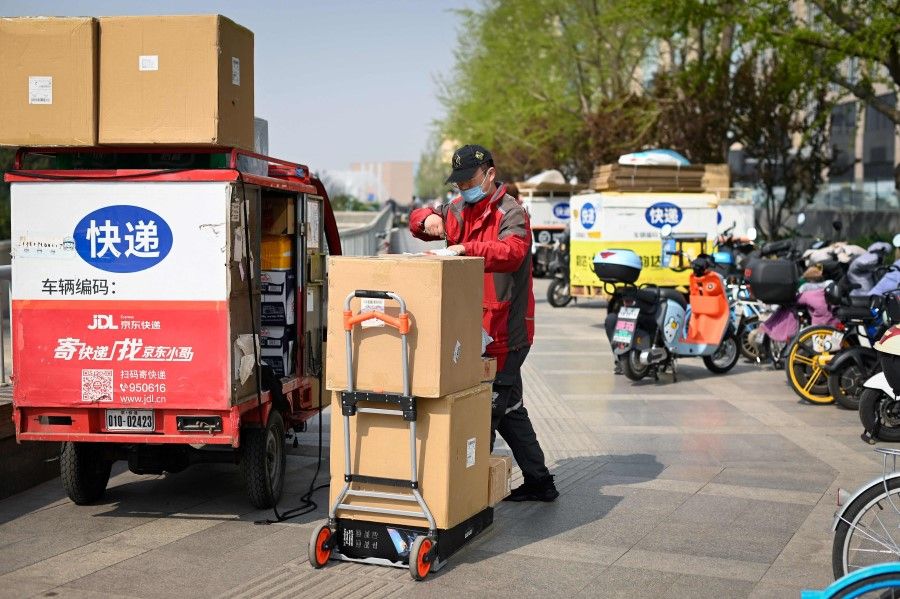 A delivery man packs boxes along a street in Beijing on 8 April 2022. (Wang Zhao/AFP)