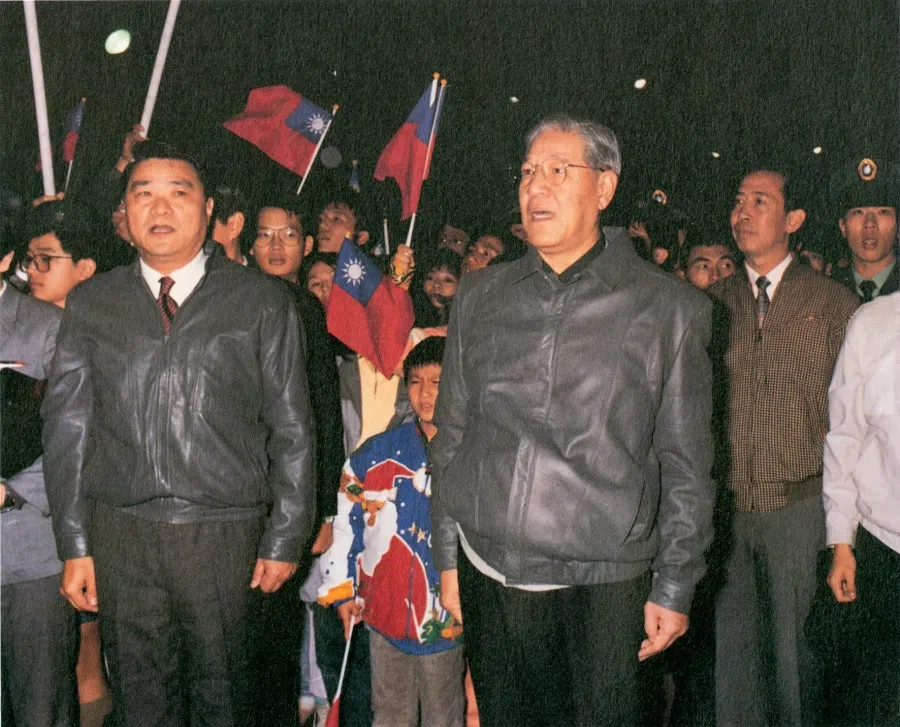 Standing at attention with the crowd, singing the national anthem, and watching the flag ascend.