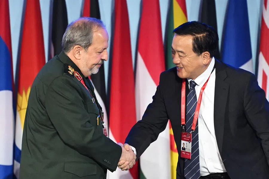 Iran’s Deputy Defence Minister Majid Ebnoreza (L) shakes hands with China’s former defence attache to the USA Zhang Li after speaking during a plenary session of the Xiangshan Forum in Beijing on 19 September 2025. (Greg Baker/AFP)