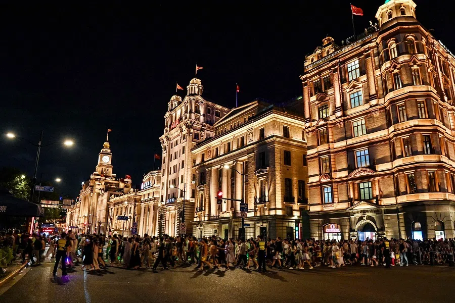People walk along a street at the Bund promenade in Shanghai, China, on 19 August 2024. (Hector Retamal/AFP)