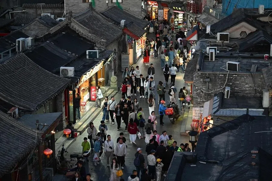 People walk at an alley in a tourist area of Beijing, China, on 3 May 2026.