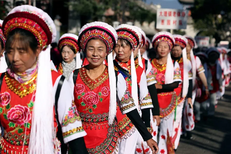 Women dressed in traditional costumes march through a street during an event to promote exercising among the elderly, in the old town of Dali, Yunnan province, China, on 11 November 2023. (Florence Lo/Reuters)