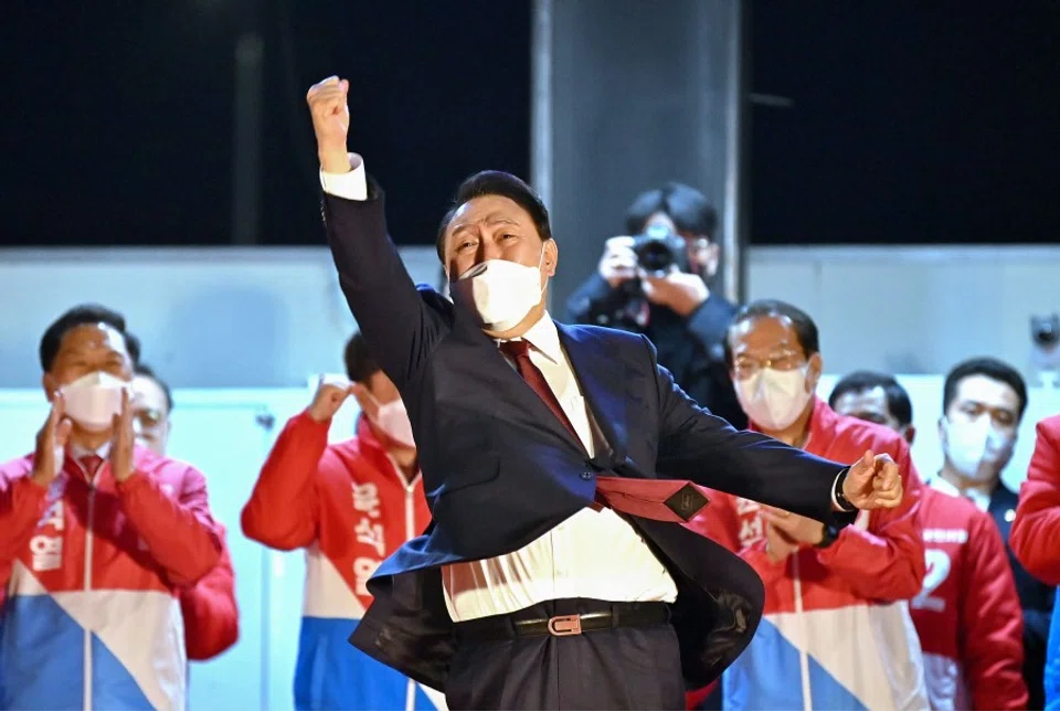 South Korea's new president-elect Yoon Seok-youl (centre) of the main opposition People Power Party gestures to his supporters as he is congratulated outside the party headquarters in Seoul on 10 March 2022. (Jung Yeon-je/AFP)