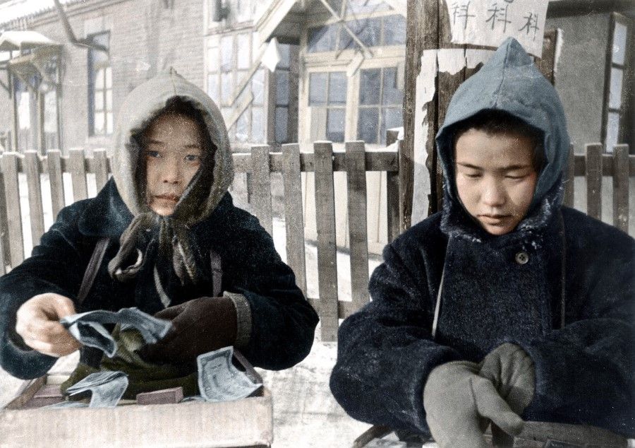 Two Japanese girls sell cigarettes on the streets of Shenyang in Manchuria, winter 1945. After the Japanese surrendered, the Japanese troops were sent by the Red Army to Siberia, and the Japanese in Manchuria were left unprotected and in poverty.