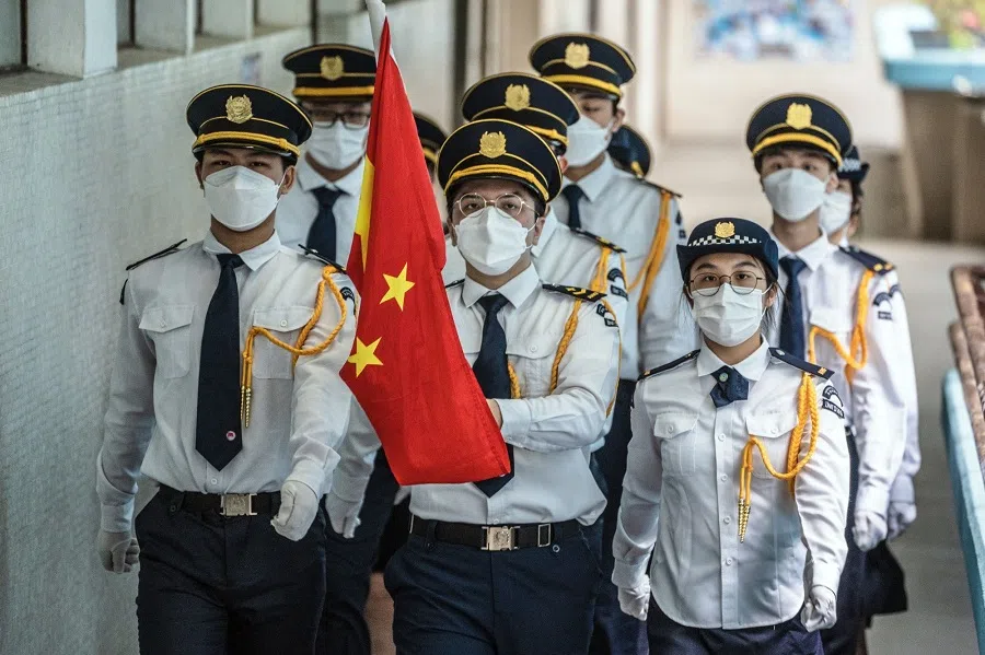 Students march with a Chinese national flag during a flag-raising ceremony to mark the 25th anniversary of Hong Kong's return to Chinese rule at Scientia Secondary School in Hong Kong on 30 June 2022. (Lam Yik/Bloomberg)