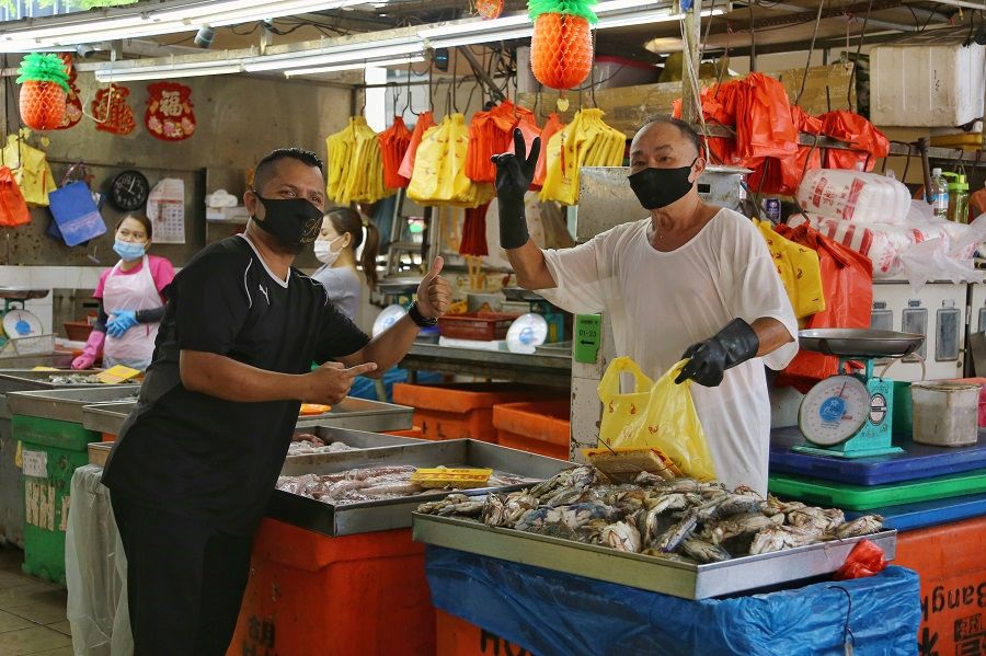 A customer poses for a photo with a stall owner at a market in Singapore. (SPH)