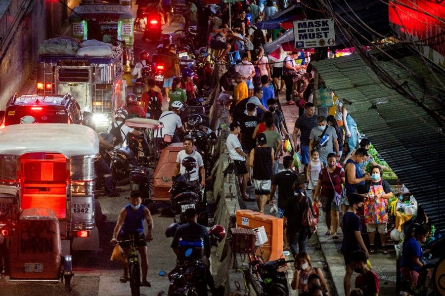 People shop at a public market in Manila, Philippines, 22 November 2022. (Lisa Marie David/Reuters)